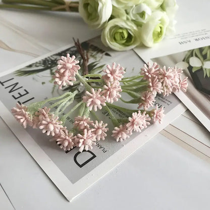 A pastel multi color decorbites decorative vase set with a delicate cluster of pink artificial flowers and green stems