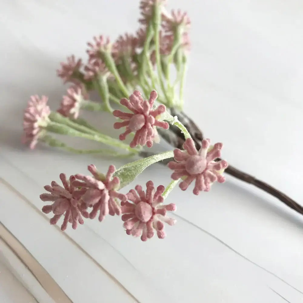 A pastel multi color decorative vase set featuring pink artificial flowers with textured petals on a dark brown wire decorbites decorative vase