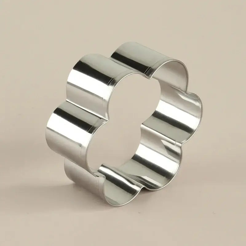 Shiny silver stainless steel easter cookie cutter shaped like a four-petaled flower from pastel painted cookie cutter set