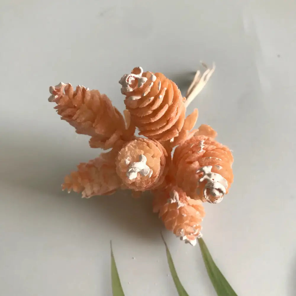 A pastel pinecone artificial flower wreath featuring orange pinecones with silver metallic tips for living room decor