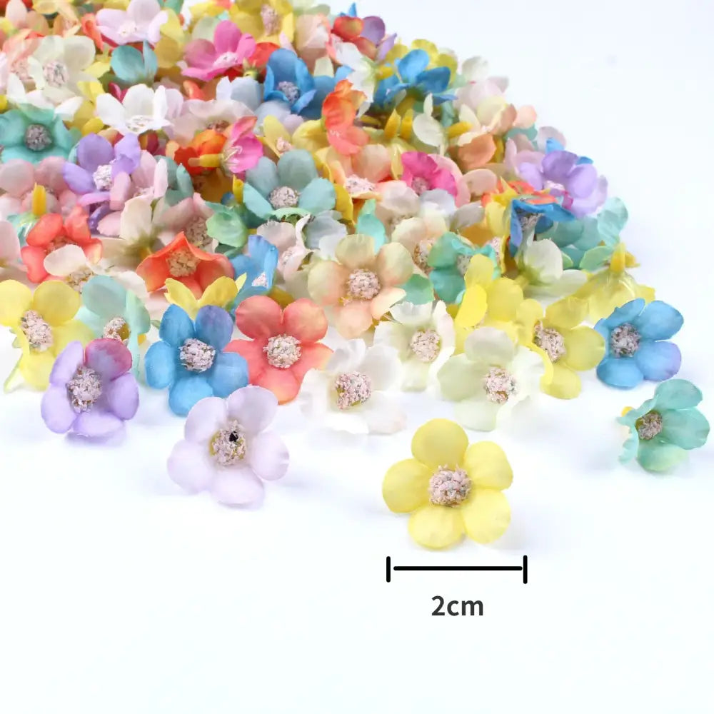 A pile of pastel pink and lavender decorbites mini daisy artificial flowers with textured centers for wedding decor