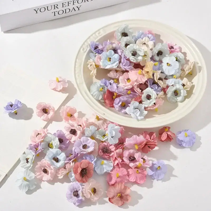 A collection of pastel pink and lavender decorbites mini daisy artificial flowers with dark centers for wedding decor
