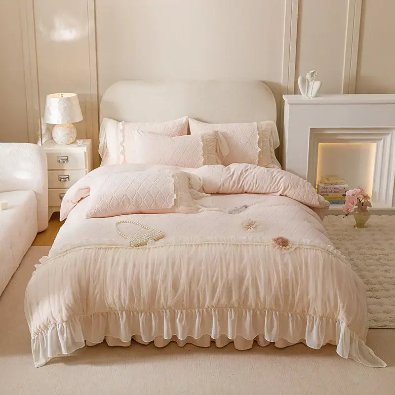 A pastel pink bedding set with blush quilted texture ruffled edges and cozy velvet lace floral accents by decorbites