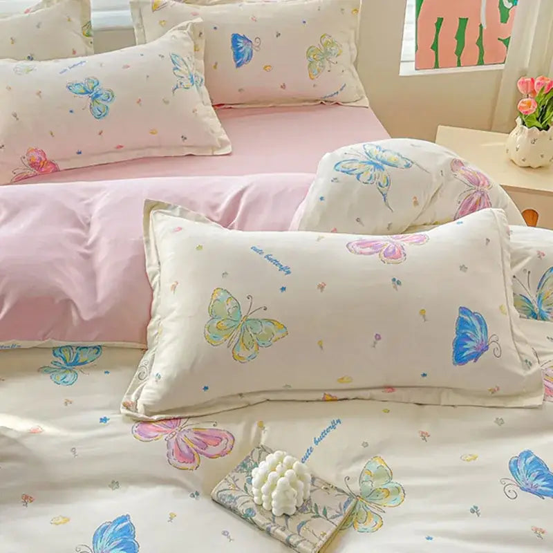 Cream-colored pillowcases with blue pink and green butterflies in pastel pink and cream decorbites cozy cotton bedding set