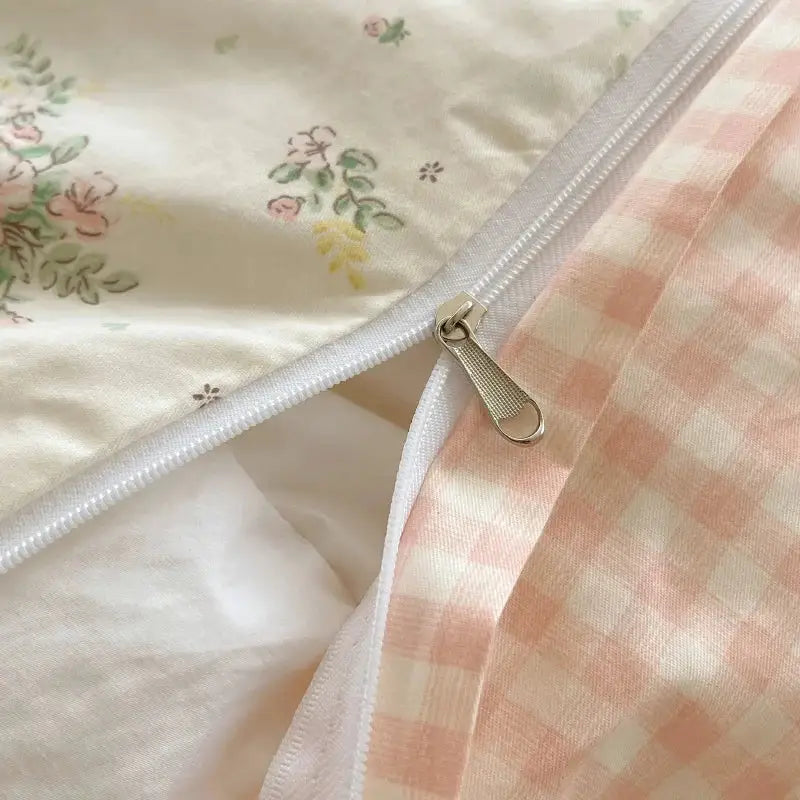 A delicate silver-toned zipper with textured pull on pastel pink and cream decorbites cotton small florals bedding set
