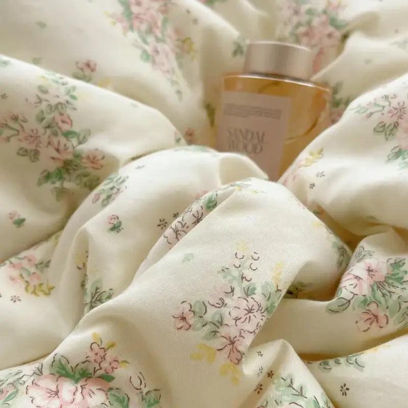 A soft cream-colored cotton small florals bedding set with delicate pastel pink and green floral decorbites cotton small patterns