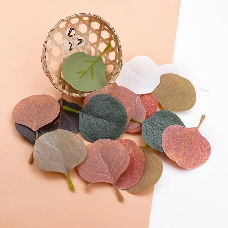 A collection of pastel pink and green silk leaf artificial plants with multicolored paper leaves for home decor