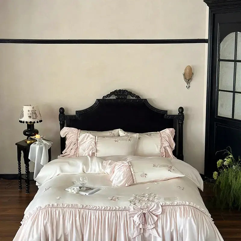 Pastel pink lyocell satin bedding set with ruffle flower embroidery and matching bow for luxury bedroom decor