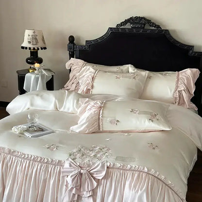 Pastel pink satin bedding set with delicate ruffle flower embroidery and intricate floral design in luxurious lyocell fabric