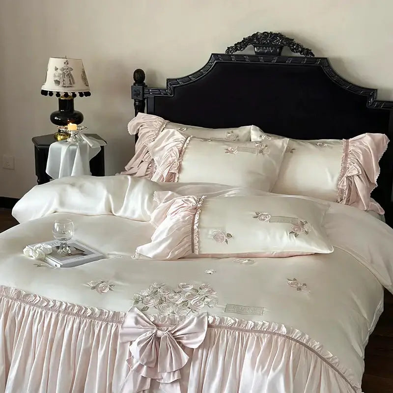Pastel pink satin bedding set with delicate ruffle flower embroidery and intricate floral design in luxurious lyocell fabric