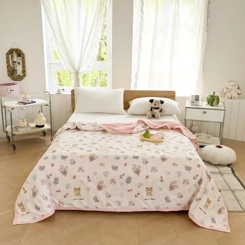Pastel pink and white quilted summer blanket featuring cartoon bear printed flowers butterflies and decorbites cartoon bear design