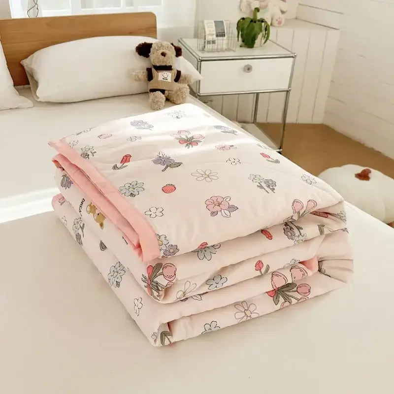 Pastel pink and white cartoon bear printed summer quilt with soft floral patterned lining featuring subtle green accents