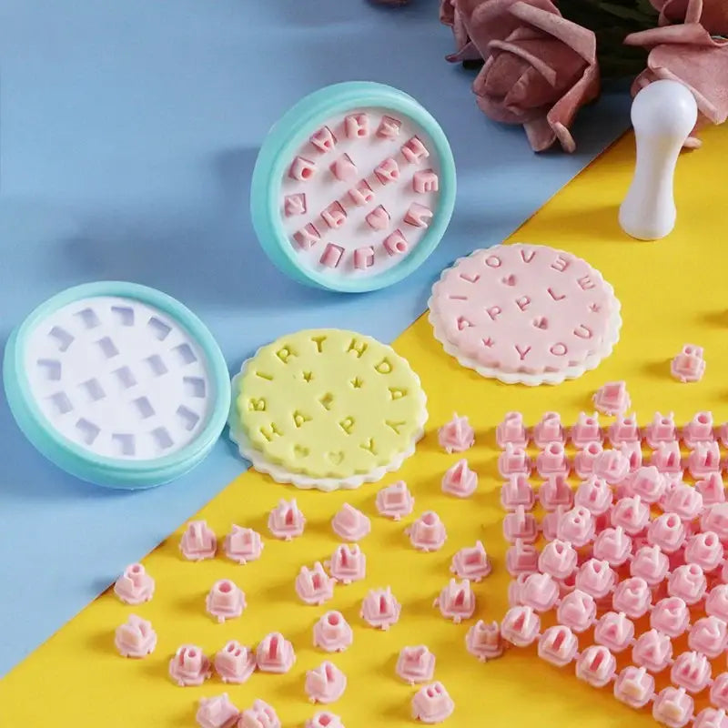 Pastel pink and yellow decorbites cookie stamps set with interchangeable plastic letter molds for personalized messages