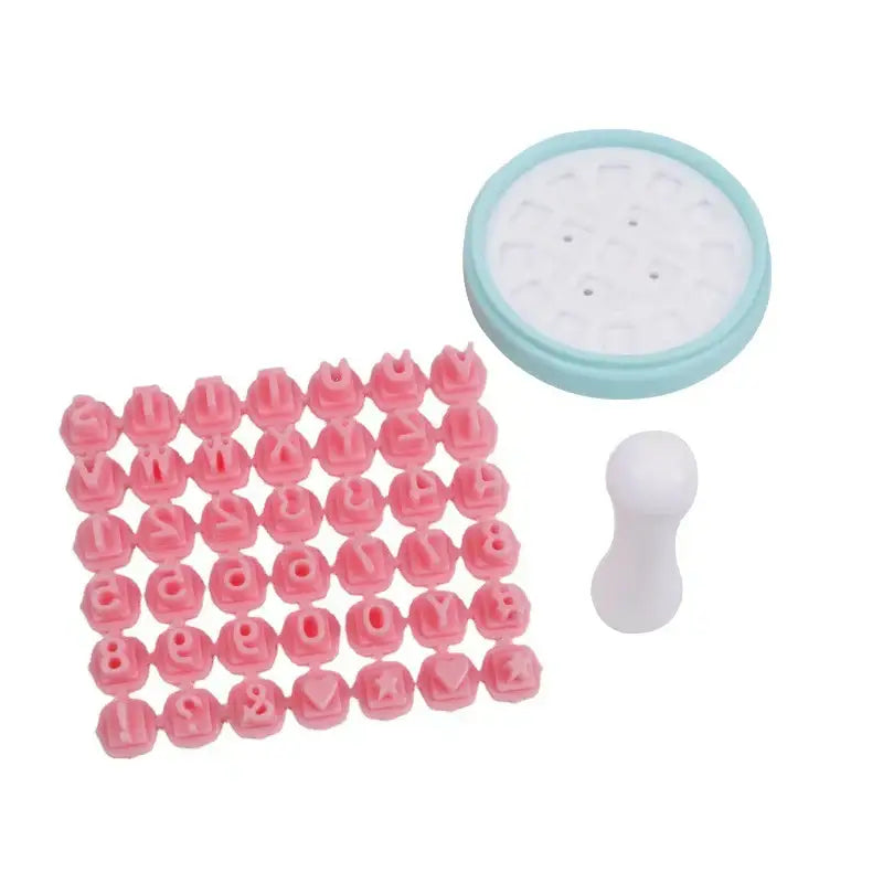 Pastel pink and yellow decorbites cookie stamps set with pink plastic letter stamps and a light blue circular base plate