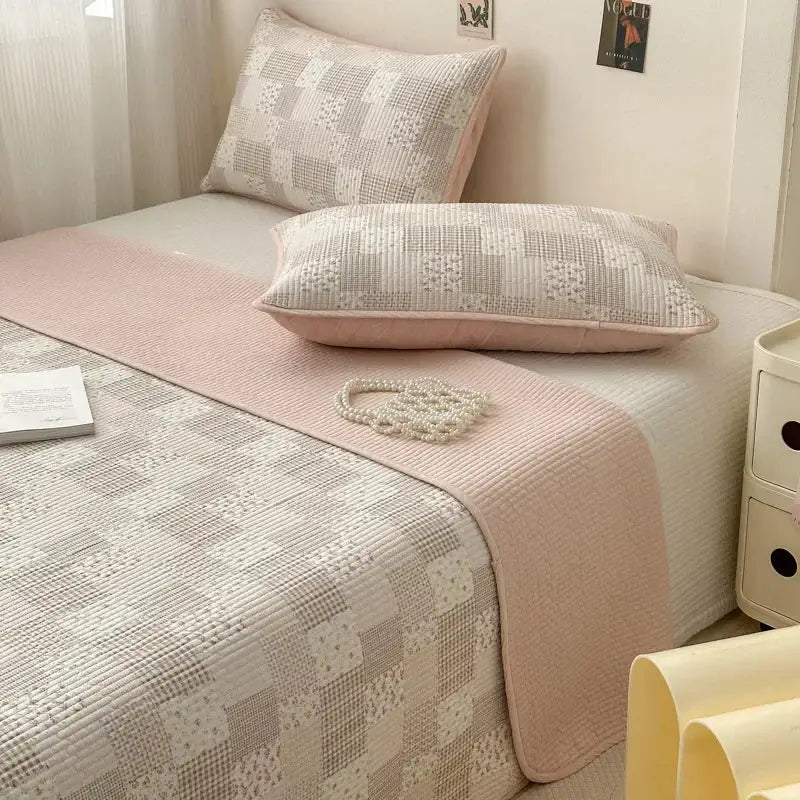Pink quilted cotton bed cover with a subtle textured pattern used as a soft anti-slip tatami mat runner