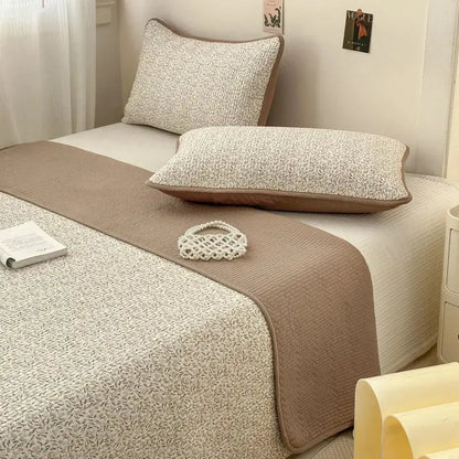 Beige quilted cotton bed cover with subtle leaf pattern and brown piping designed as a soft anti-slip tatami mat
