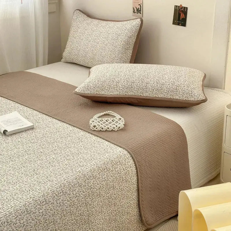 Beige quilted cotton bed cover with subtle leaf pattern and brown piping designed as a soft anti-slip tatami mat