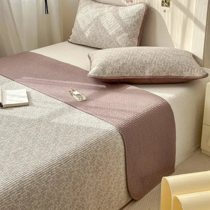 A soft pink and beige quilted cotton bed cover with ribbed texture designed as an anti-slip tatami mat