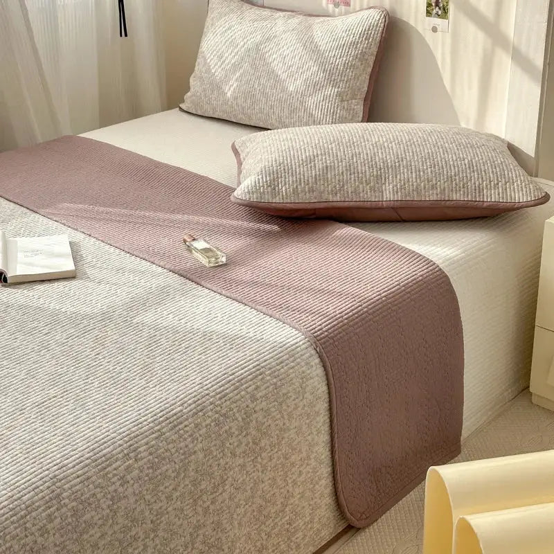 A soft pink and beige quilted cotton bed cover with ribbed texture designed as an anti-slip tatami mat