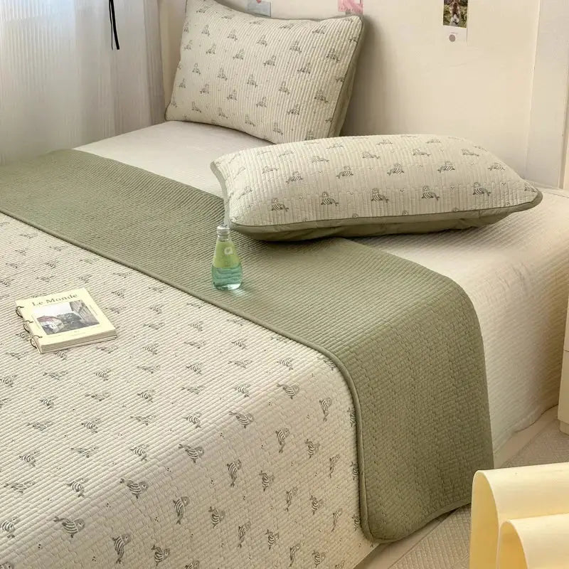 A soft sage green quilted cotton bed cover with subtle animal patterns designed as an anti-slip tatami mat