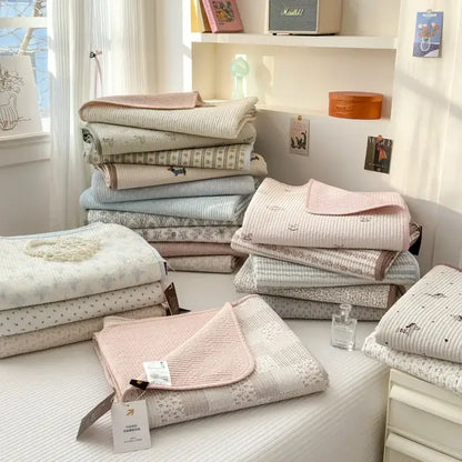 Stack of pastel-colored quilted cotton bed covers with soft textures suitable for tatami mat and bedroom use