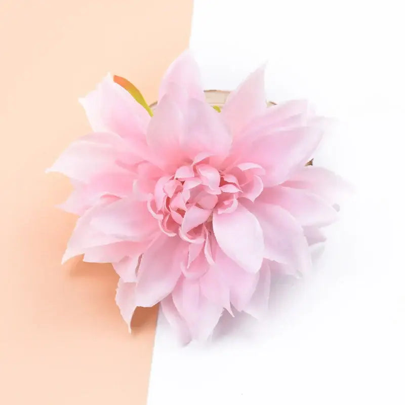 A delicate pink silk gerbera flower with layered petals and soft fabric texture for wedding and living room decor