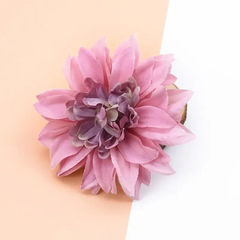 A delicate pink and purple silk gerbera flower with layered fabric-like petals for wedding and living room decor