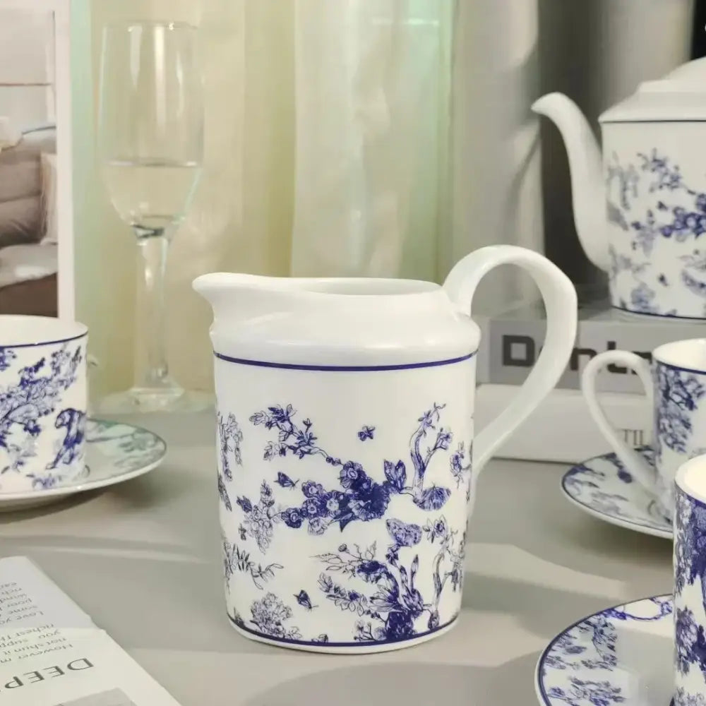 White ceramic creamer with intricate blue floral and butterfly patterns from decorbites jungle lion bone tea set