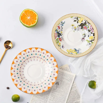 Two ceramic bone china coffee cup saucers with orange geometric and pastel floral patterns for tea time dining set