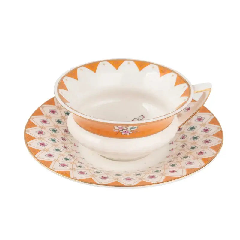 Orangish pastoral floral bone china flower coffee cup with scalloped rim resting on matching coffee cup saucers for tea time