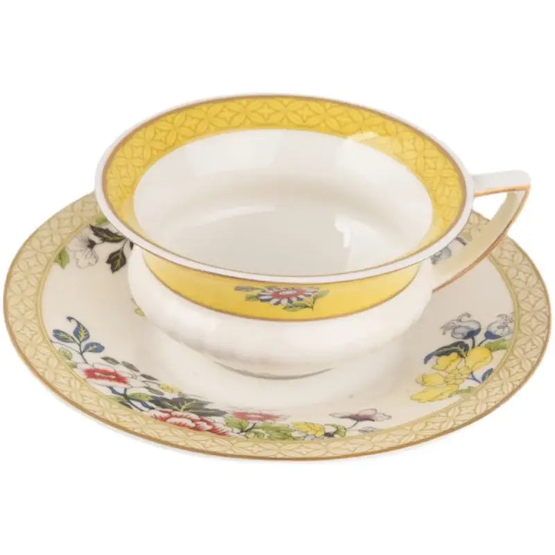 A delicate pastel floral bone china flower coffee cup with vibrant yellow rim and gold patterns in a tea time set