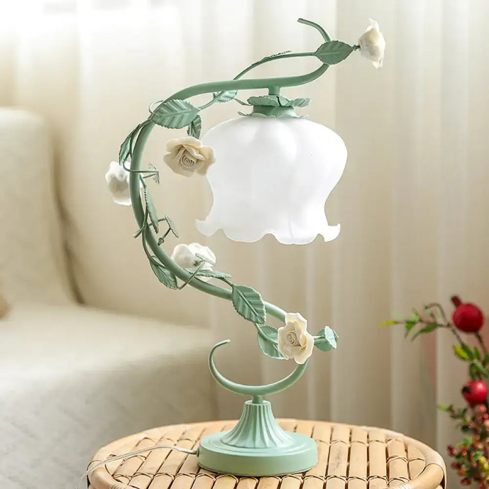 A delicate mint-green metal table lamp with white rose vine design and frosted glass shade featuring usb charger