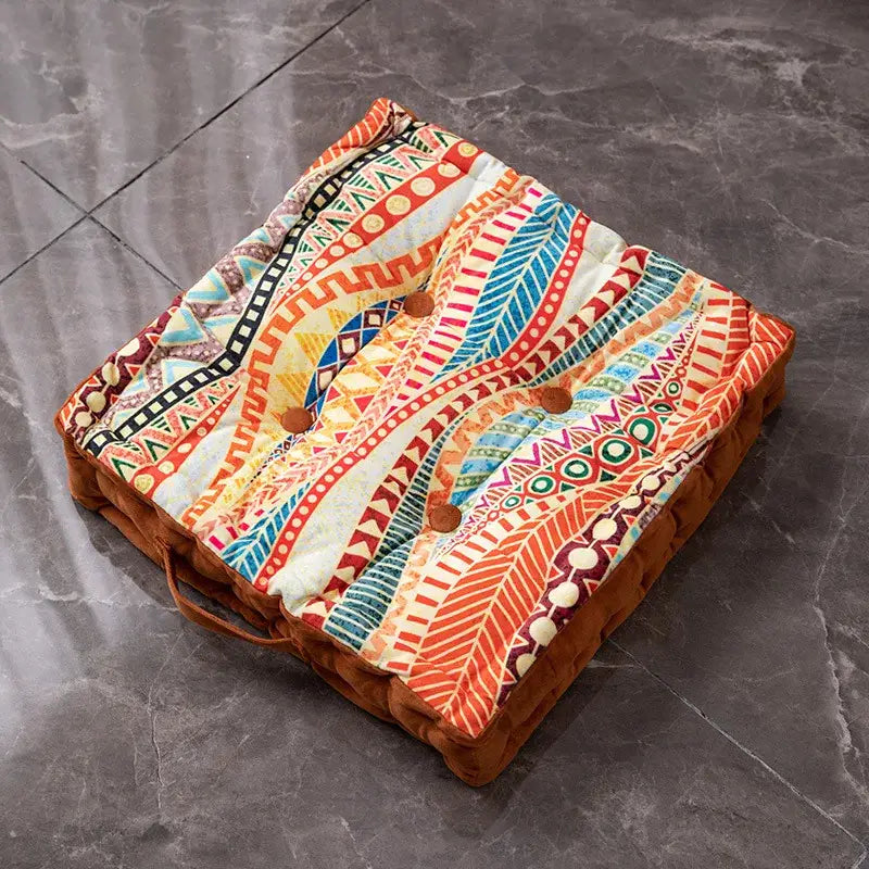 A vibrant bohemian mandala velvet floor cushion with colorful geometric pattern and brown button closures for reading nook decor