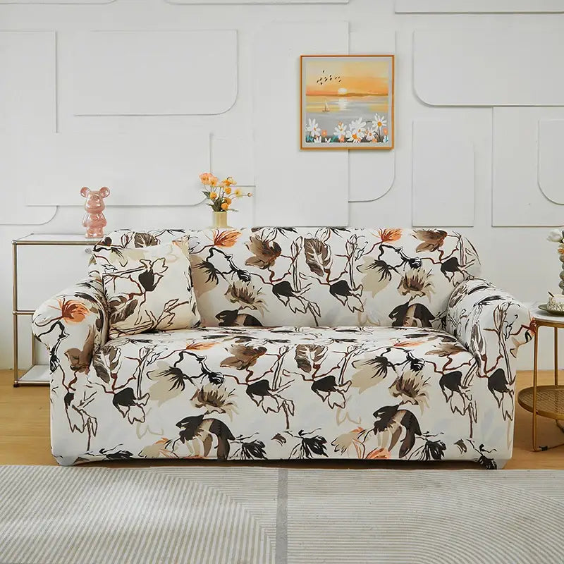 A cozy sofa draped in a stretchy cream fabric cover with black brown and orange botanical print for living room use