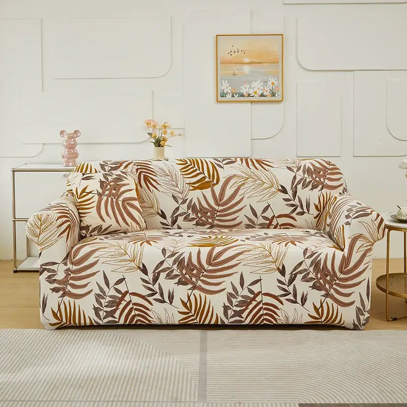 Beige sofa with a stretchy patchwork mandala print fabric cover featuring tropical leaves in brown gold and dark green