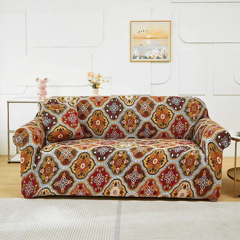 A vibrant stretchy patchwork mandala sofa cover with intricate geometric pattern in reds golds and earth tones for living room