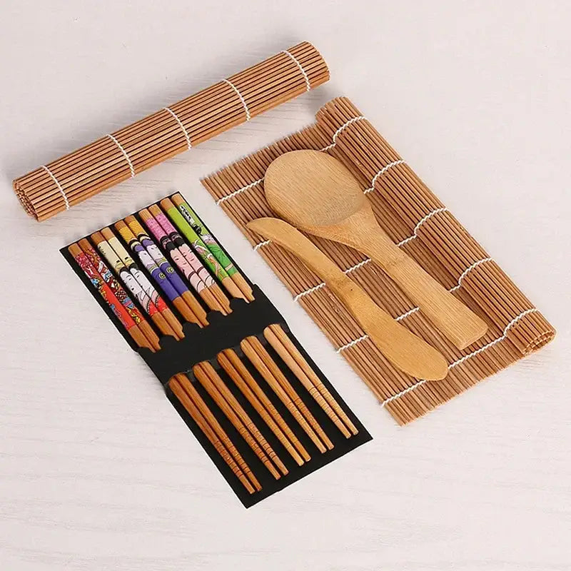 Set of patterned bamboo chopsticks with colorful designs wooden spoon and knife on rolled bamboo mat sushi maker set