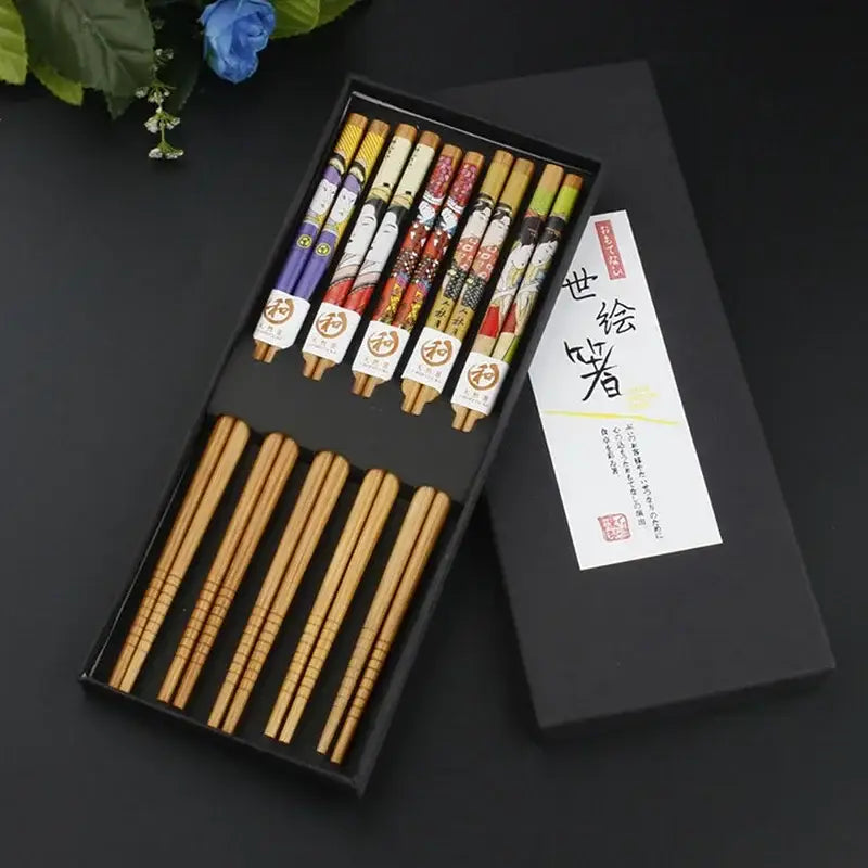 Set of decorative wooden chopsticks with colorful japanese illustrations in a natural wood sushi maker set gift box