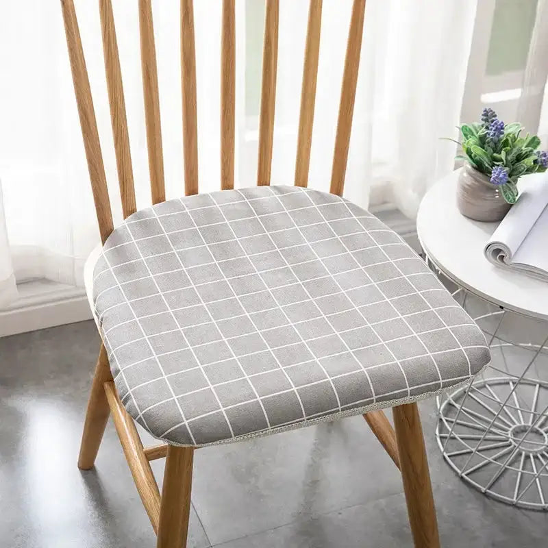 Gray checkered decorbites cotton hemp chair cushion with white grid pattern snugly fitted on wooden dining chair seat