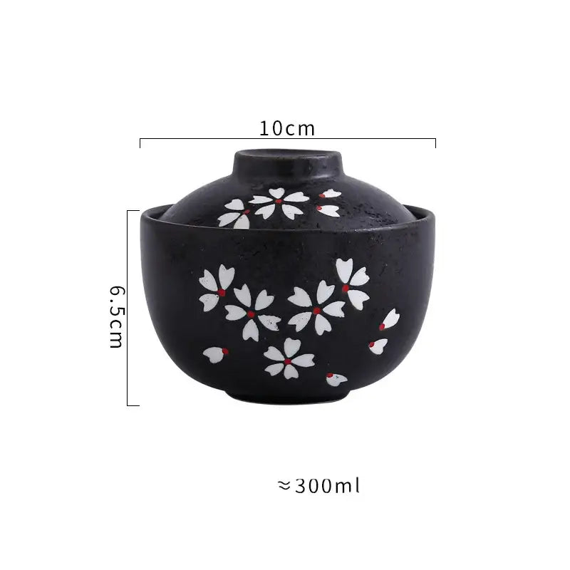 Black ceramic stew pot bowl with matching lid featuring white cherry blossom patterns and red centers for dining use