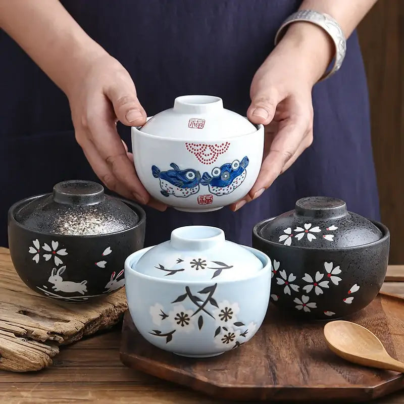 White ceramic stew pot bowl with blue fish and red dot patterns and a matching lid for dining room use