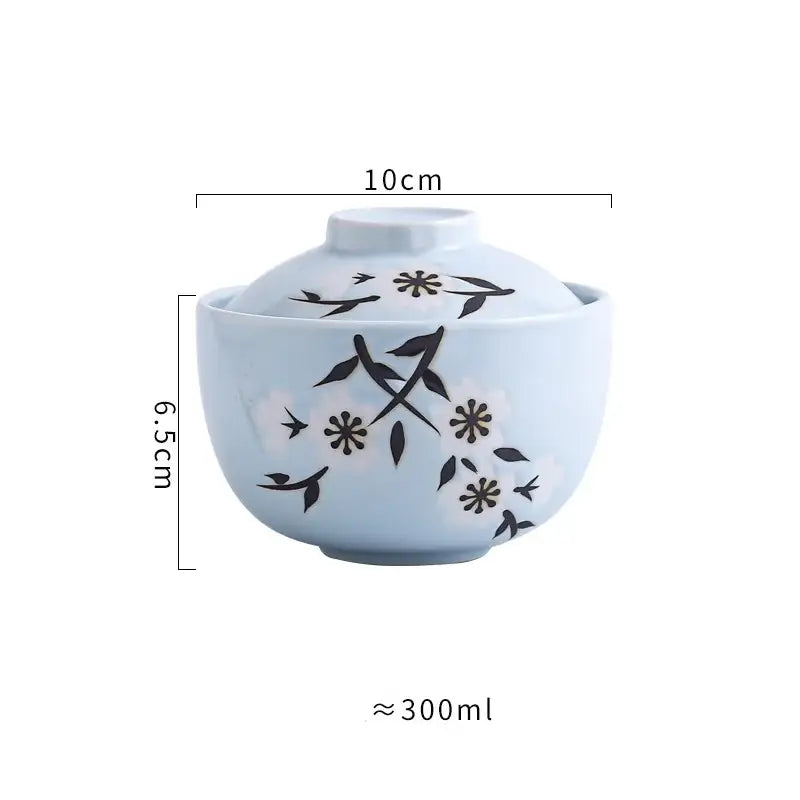 Light blue ceramic stew pot bowl with matching lid featuring black floral and bird motifs for dining use