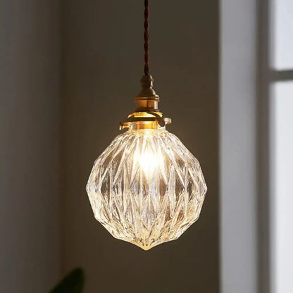 Clear faceted glass ceiling light with brass fixture and twisted cord in pauline modern industrial sphere design for living room