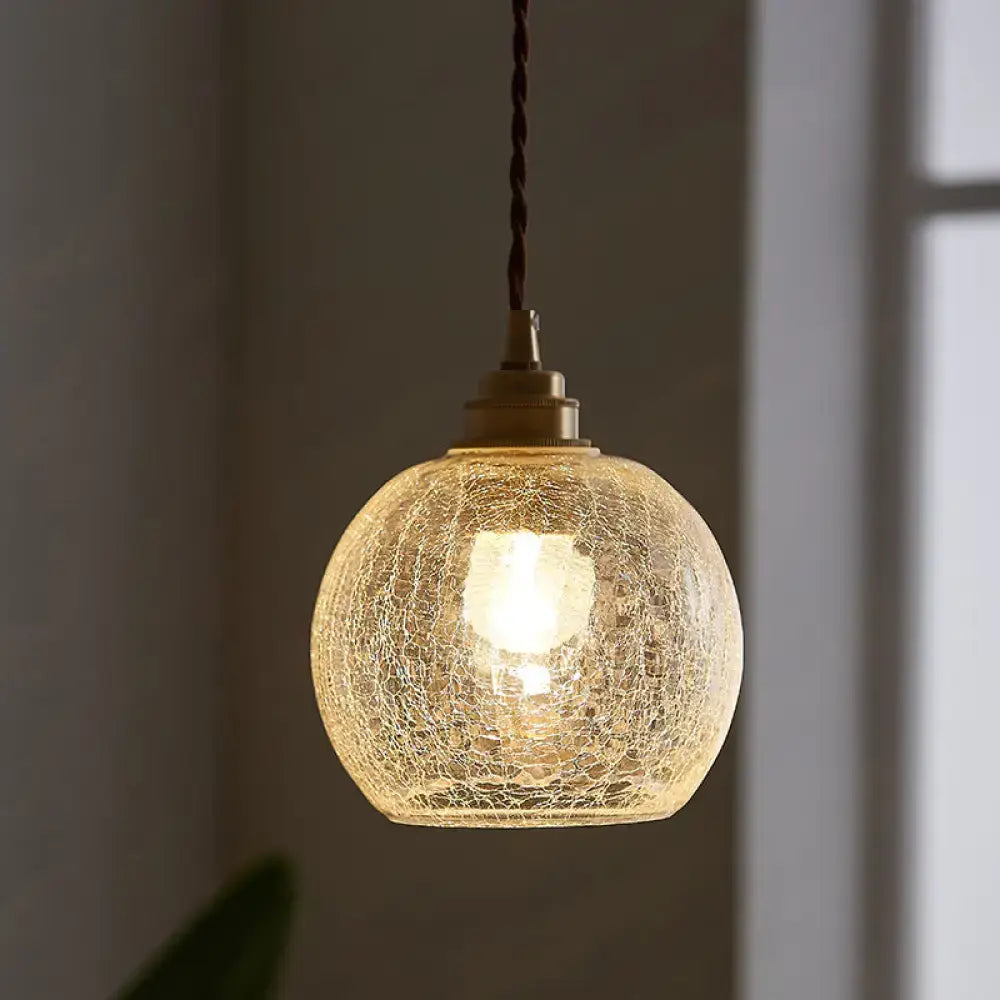 A warm glowing decorbites pauline modern industrial ceiling light with crackled clear glass and brass hardware