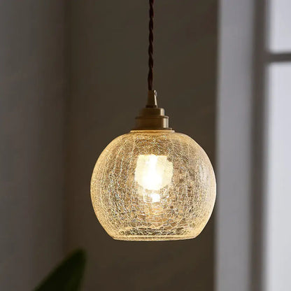 A warm glowing decorbites pauline modern industrial ceiling light with crackled clear glass and brass hardware