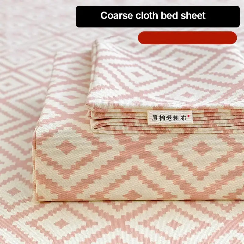 A folded peach and cream geometric bed sheet set made from textured cotton for a cozy bedroom bedspread