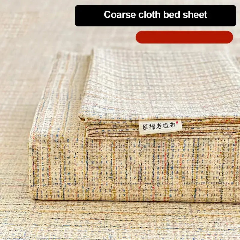 Folded beige coarse textured bed sheet set with woven pattern and subtle multicolored threads for bedroom use