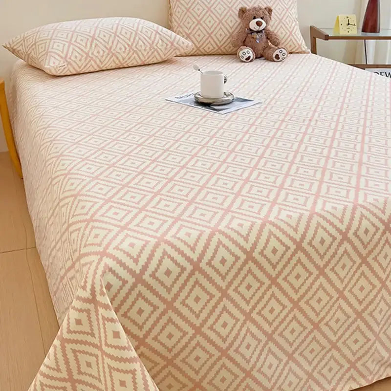 Peach and cream geometric patterned bed sheet set with textured pink and cream bedspread for bedroom use