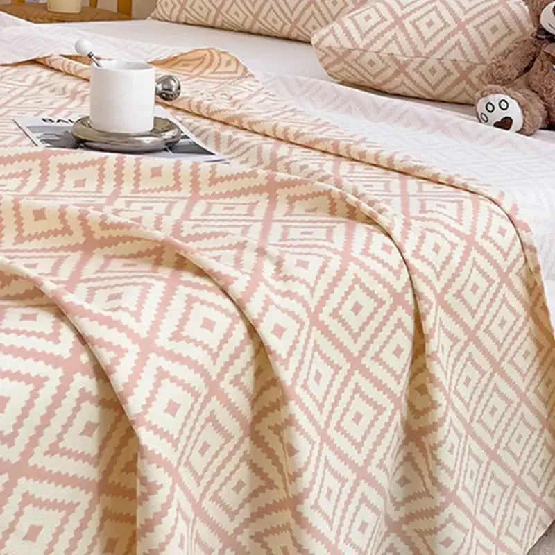 A soft peach and cream geometric textured throw blanket complementing the peach and cream bed sheet set