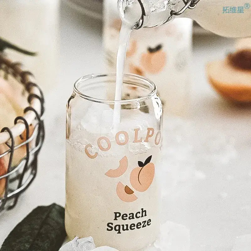 Clear glass cup with peach fruit prints and peach squeeze text in a peach print can shape glass cup for dining room use